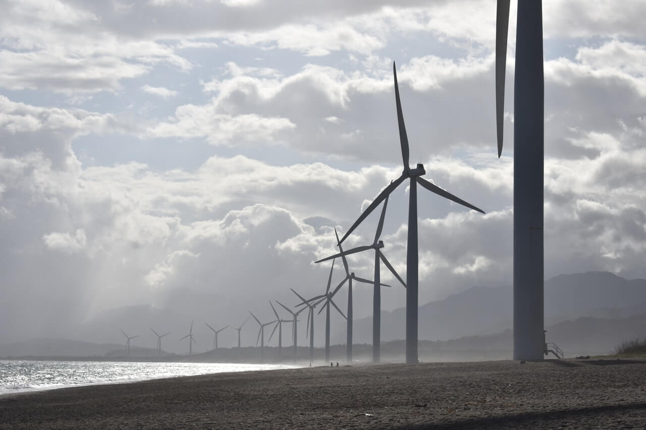 Een foto van een landschap met daarin een rij windmolens